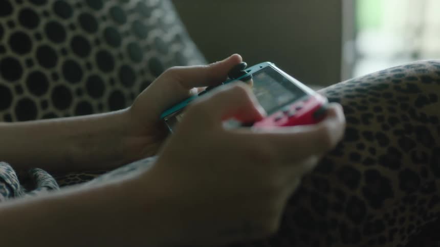 A close up of a person playing a hand held video game
