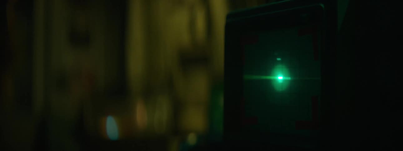 Person watches as signal flows across display in dim room