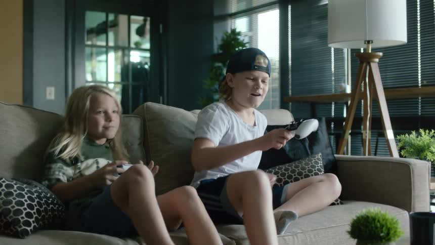 Siblings are hanging out indoors and playing video games