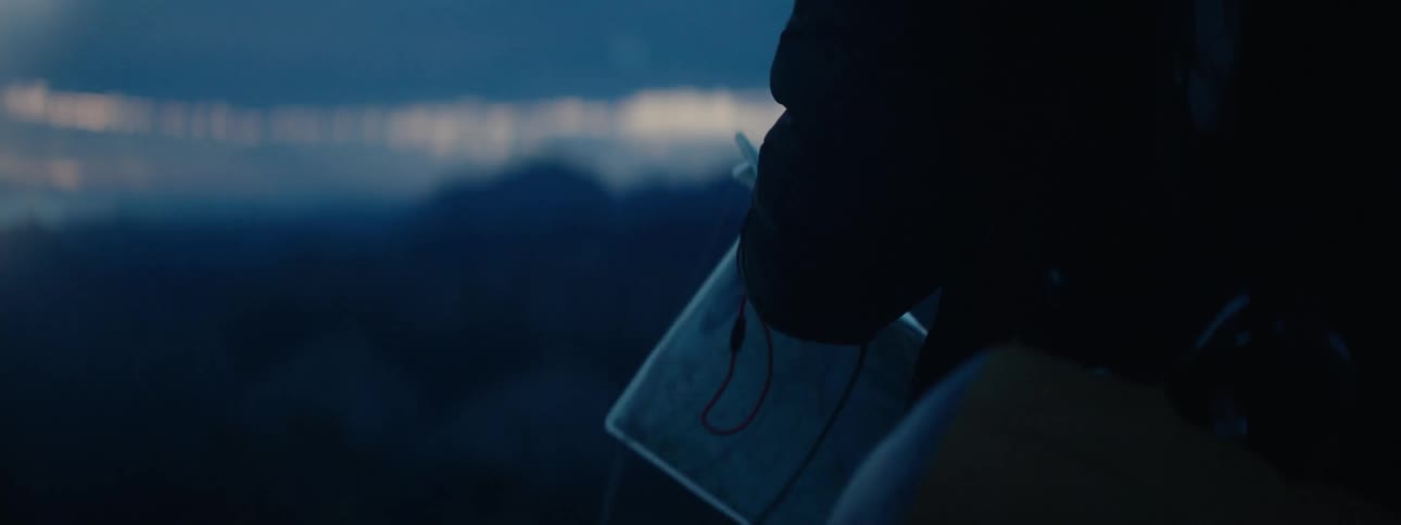 Hiker stands with paper overlooking valley