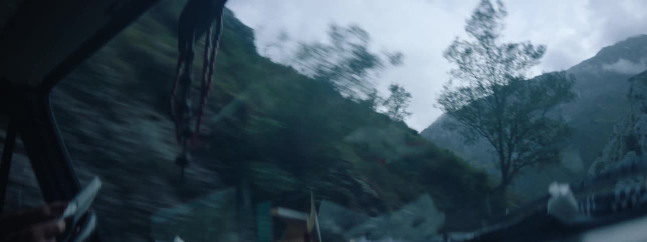 A person is driving through a rocky landscape