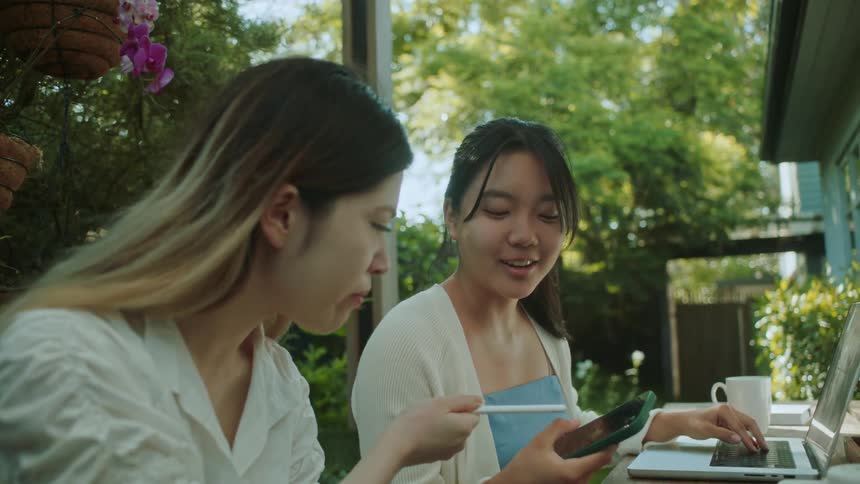 Two friends are talking together and sitting outdoors