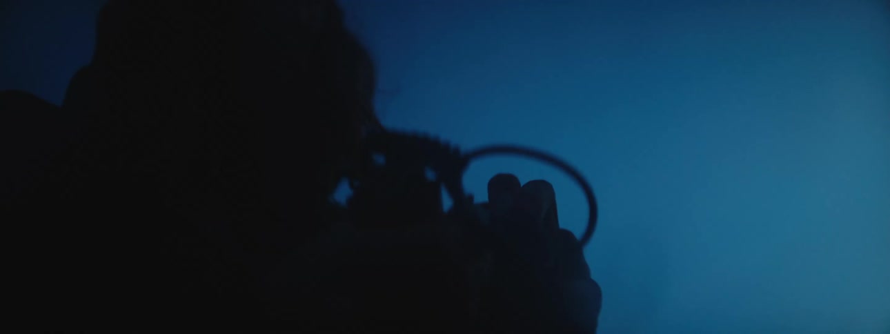 A silhouetted person fidgeting with an object in the dark