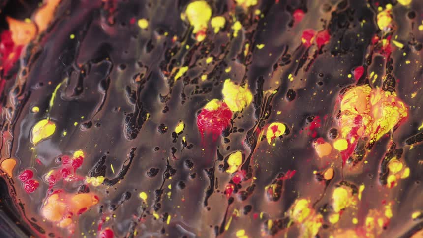 Brightly colored paintlike liquid slowly runs down a flat surface