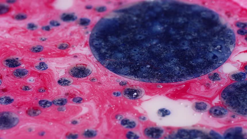 Blue and pink paint swirled together and also bubbled into circles