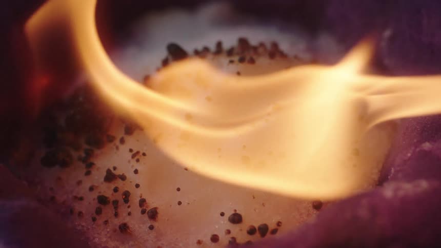 A close up of a flame burning off a white substance