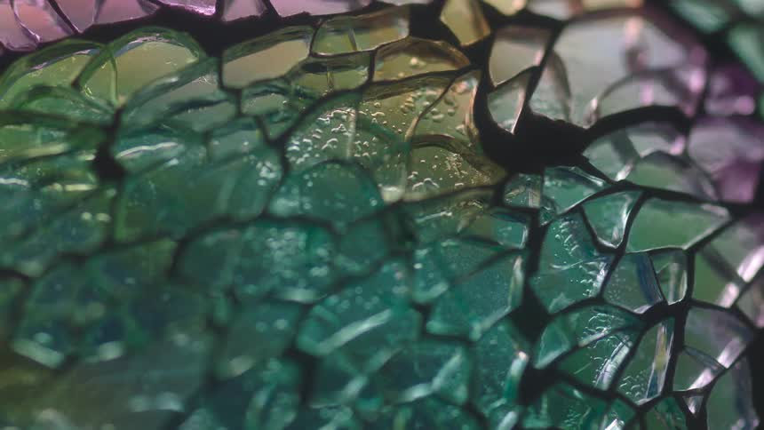Extreme close up of the details on a stained glass window reflecting light