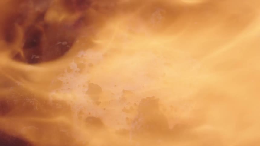 Fiercely burning flames quickly consume and burn a white substance