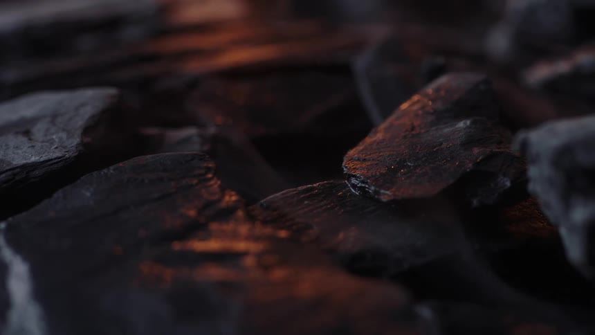 The fire reflects on the coals