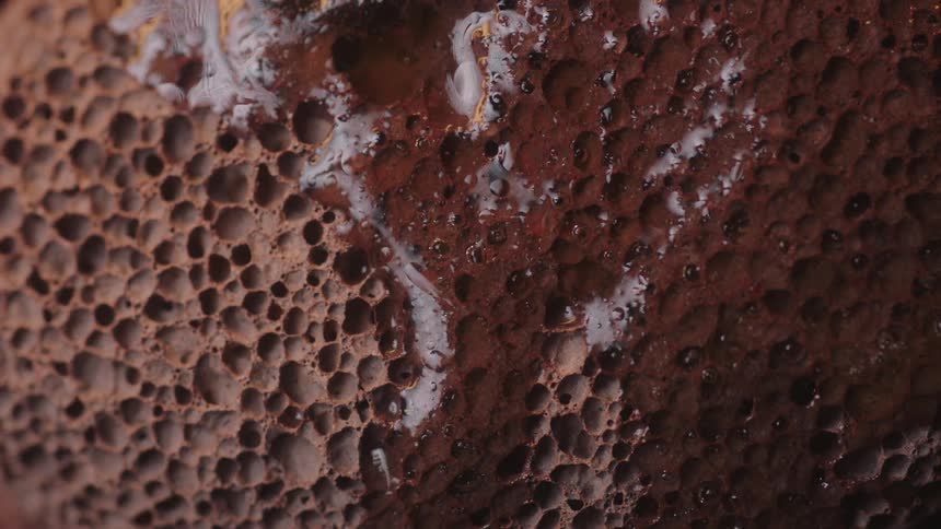 A porous surface has a thick paintlike liquid coating part of it