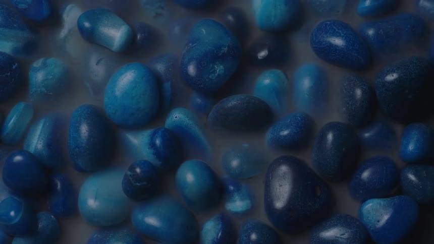 Blue painted rocks with smooth edges and steam rolling over them
