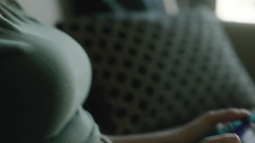 An up close of a girls face and the game she is playing in her hands