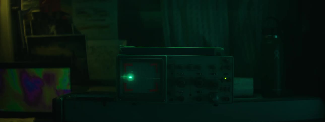 Close up of the flat green line on an electrocardiogram machine inside a dark room