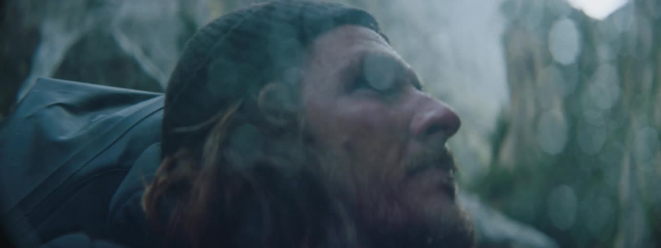 A man is washing his face while hiking outdoors