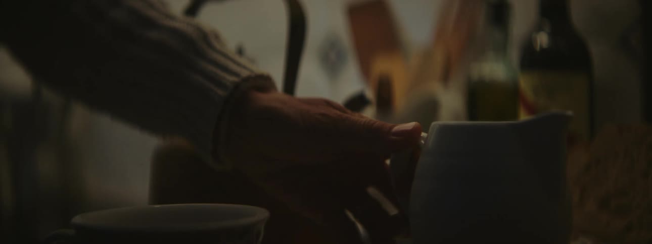 Close up of a person pouring cream or milk on a cup in the kitchen at home