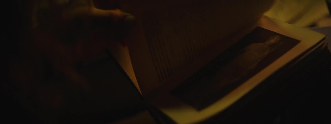A close up of a person turning pages in a book showing picture and text