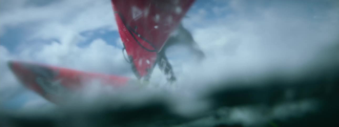 Slow motion footage of a man windsurfing in the ocean at daytime