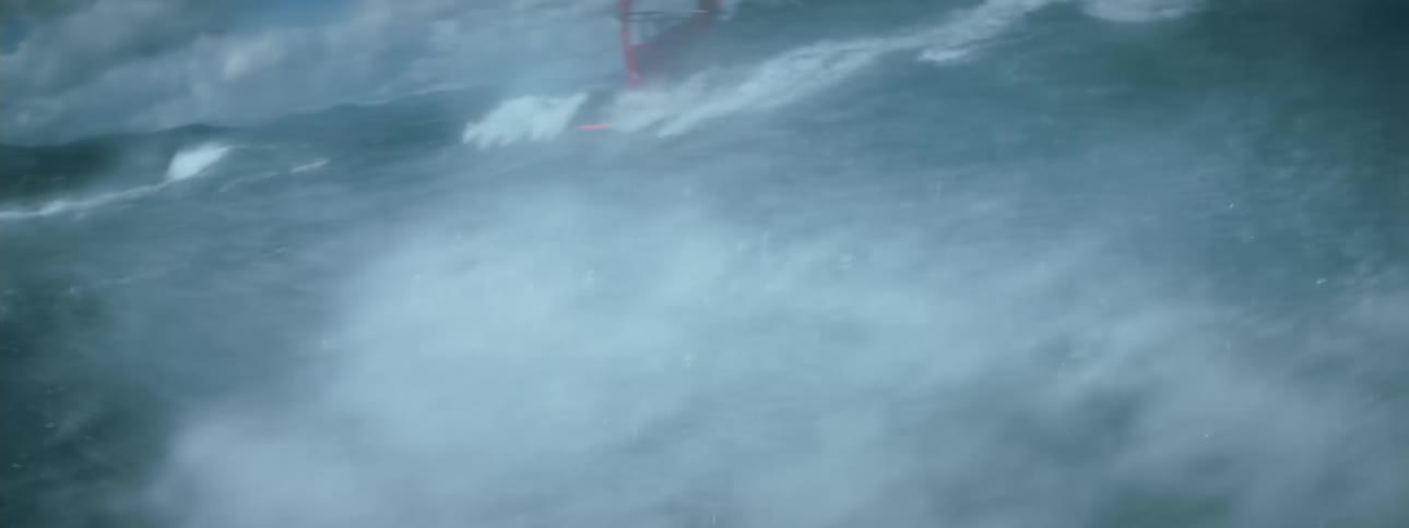 Footage of a man windsurfing over the waves in the ocean at daytime
