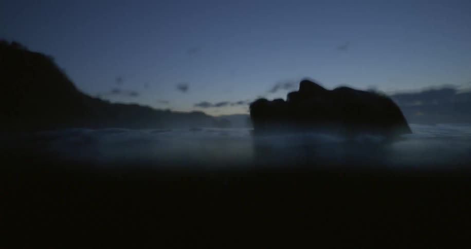 Silhouette of a man floating on his back on the surface of a lake at morning or evening
