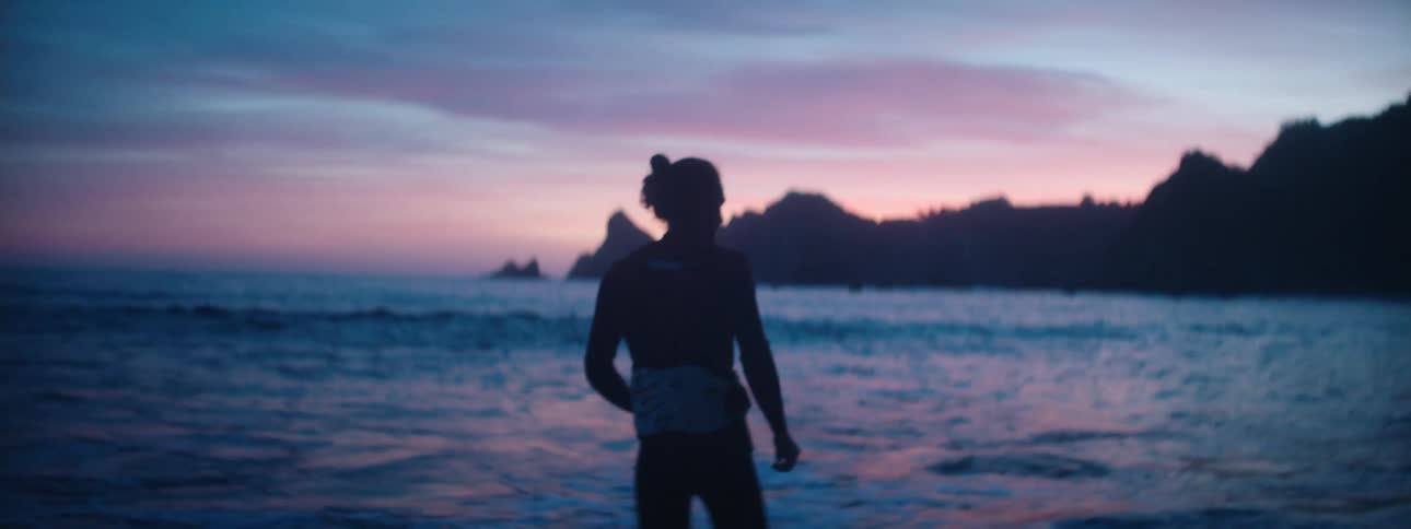 A man is walking at the beach during dusk