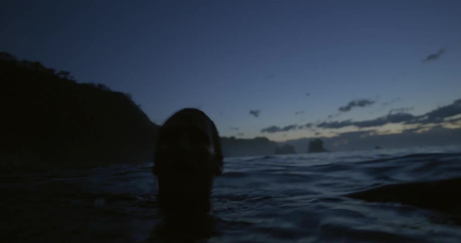 A man flailing in the water bobbing up and down
