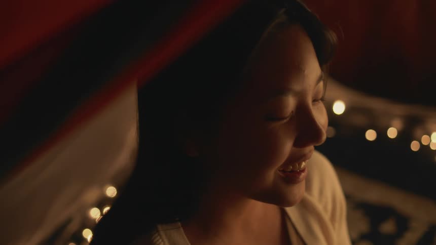 The view is of a young woman that is inside of a tent