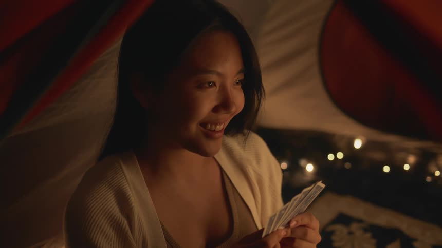 A woman holding cards laughs