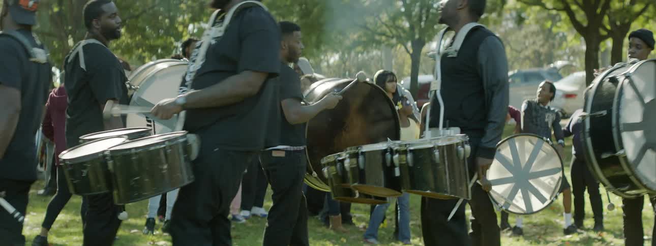 A group of people beat drums