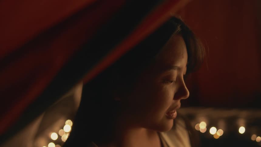 A close up of a womans face as she looks intently ahead and then talks