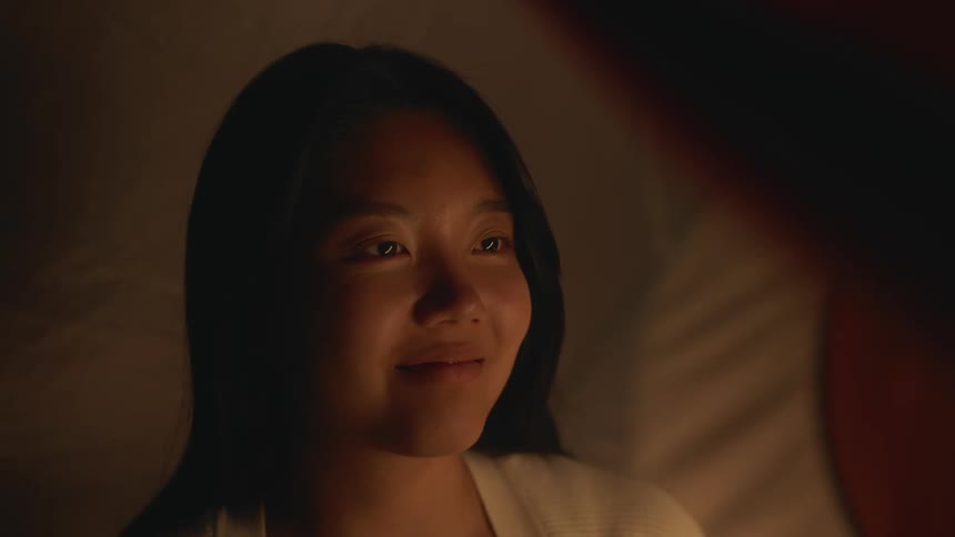 A womans face looking serious and then smiling