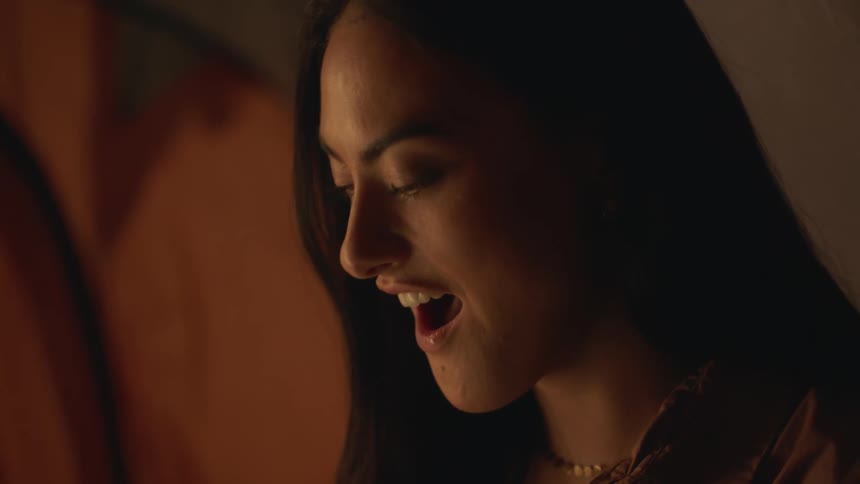 A young woman is inside of a tent and is smiling