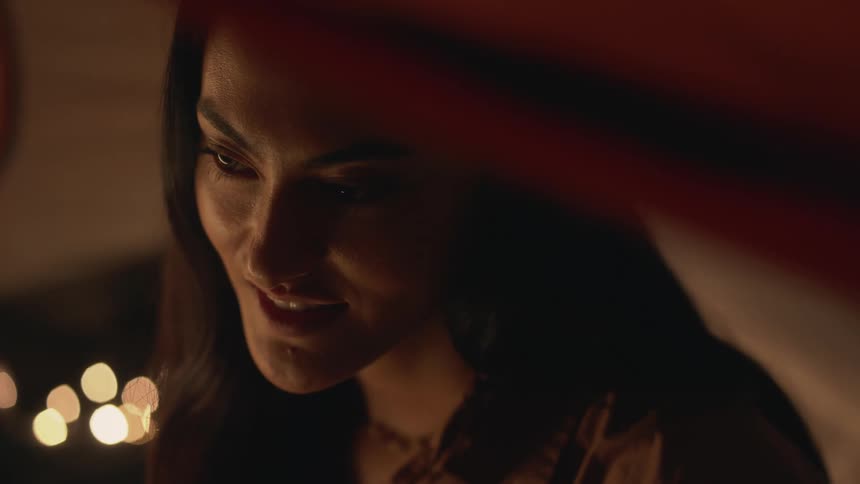 A woman smiles at night