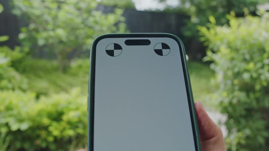Smartphone in a womans hand with a garden background