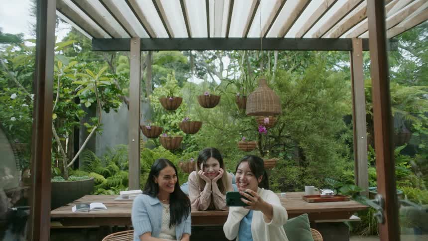 A group of friends are outdoors and taking pictures with there phone