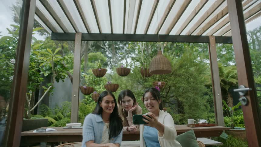 The view is of friends hanging outside in the middle of the day time
