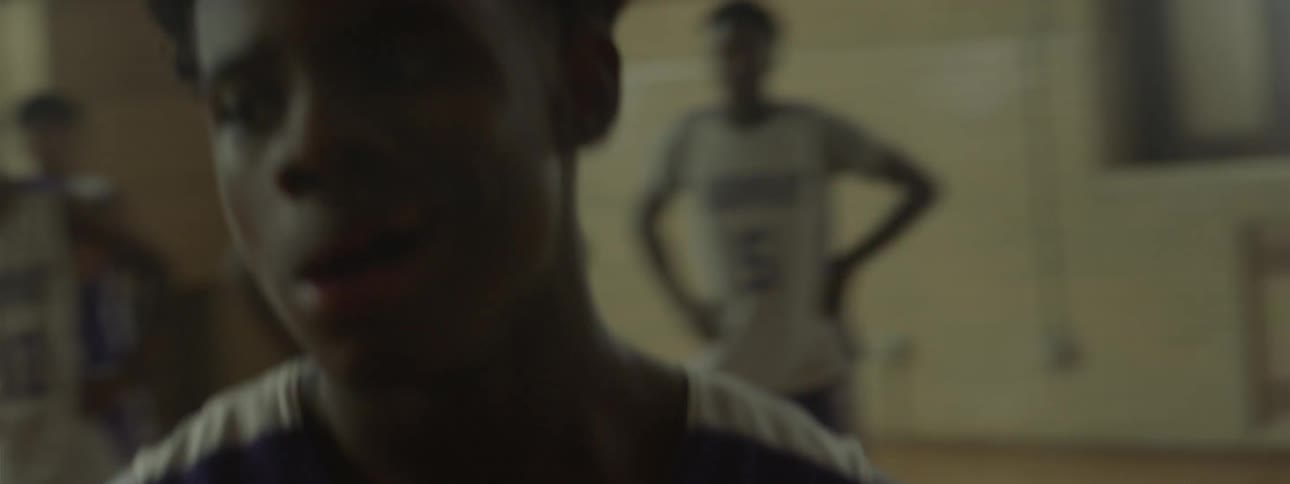 A boy walks onto a basketball court