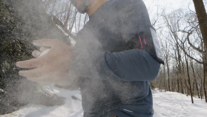 Man chalks hands before climb, in snow, dust
