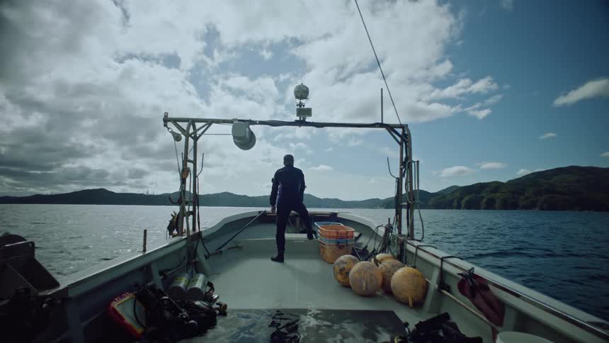 A man staring out to the sea on a boat
