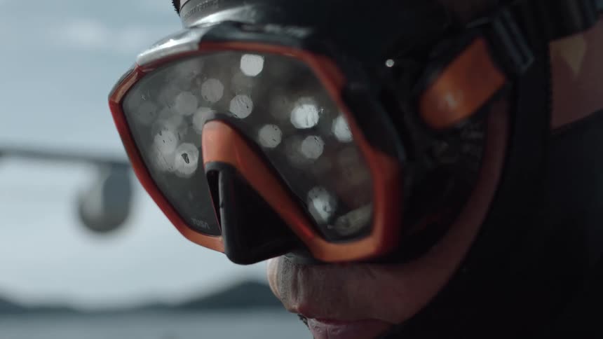 A man is wearing goggles and swimwear gear outdoors