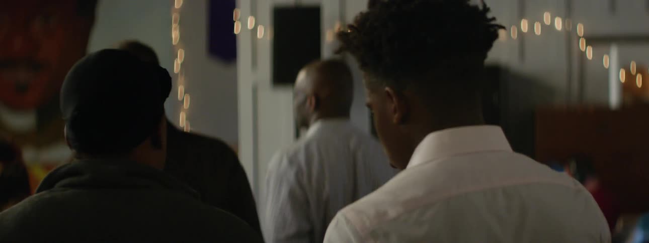 A man in a white shirt cuts through a crowd
