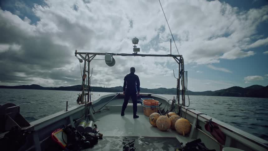 A man is sailing a boat on a body of water