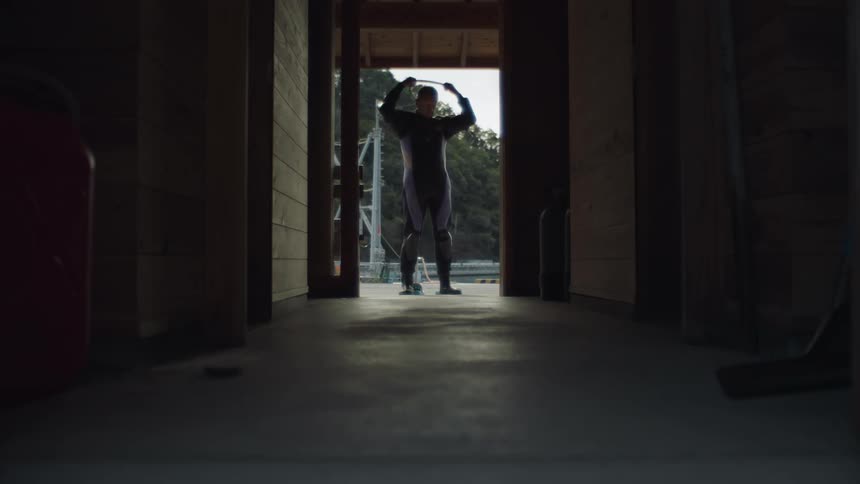 A man is putting on a jumpsuit