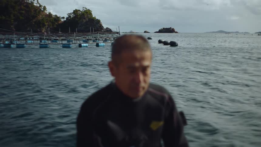 An older man is outdoors by the lake in the day time