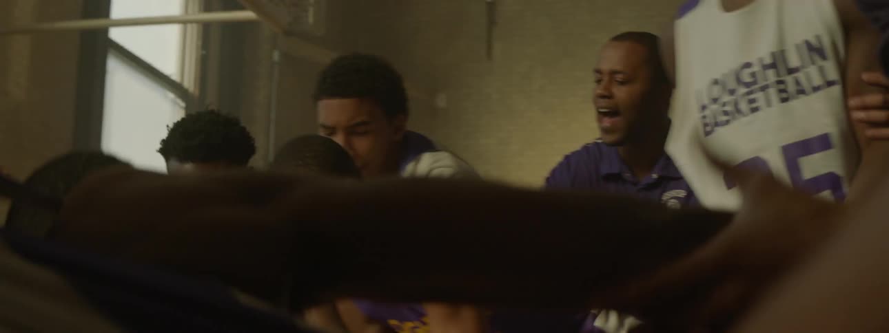 A group of boys in basketball jerseys fight