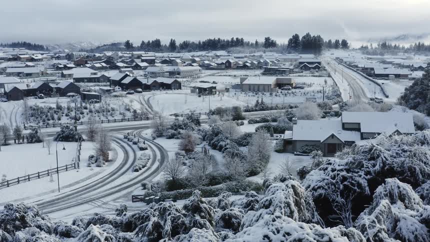 The view is of a town in the winter time in the middle of the day