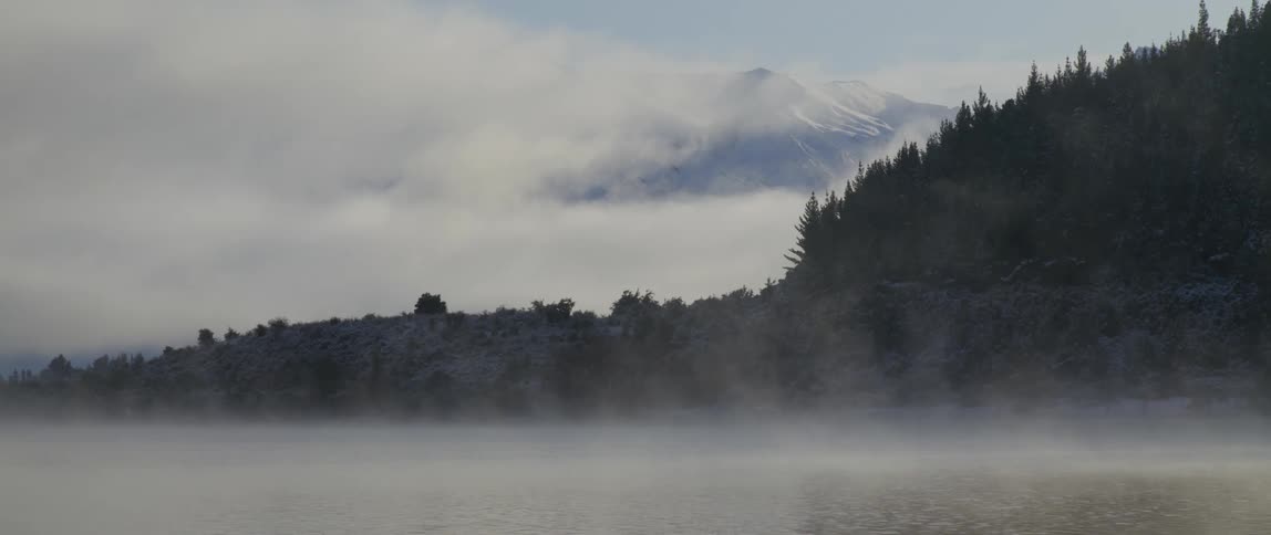 Aerial view of a river covered with fog is displayed