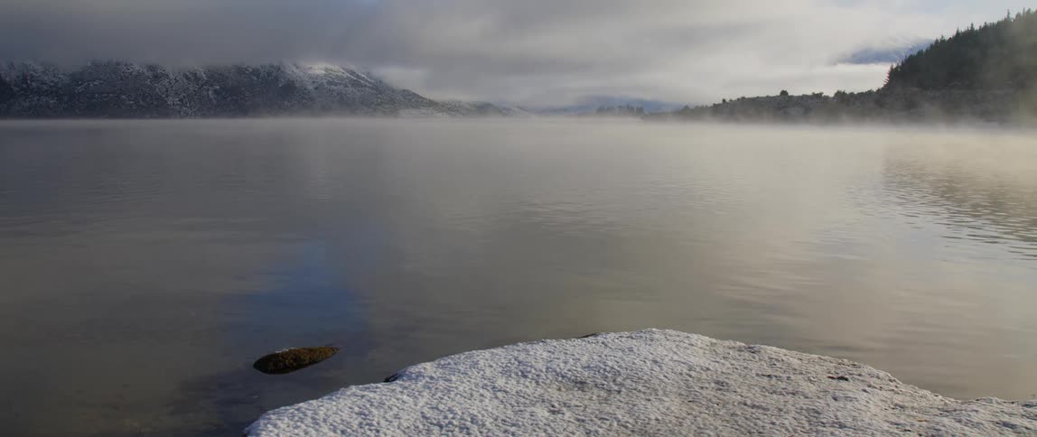 Mist is covering the body of water during midday
