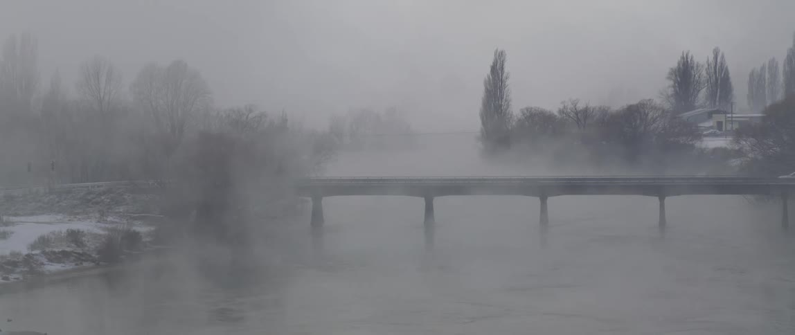 Mist or fog cover a bridge over a river in the morning