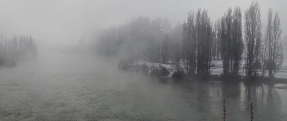 Fog and mist is covering the body of water at midday