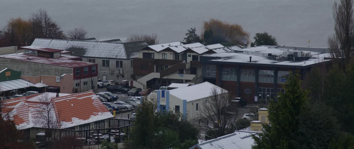 Wide shot of a group of houses and parking lots in a small town at winter